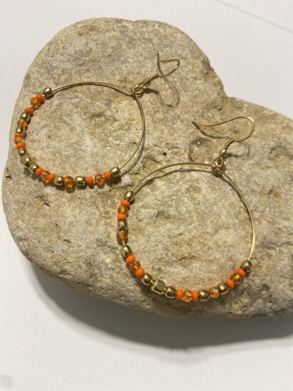 Orecchini a cerchio in oro con perline dai colori vivaci. Design leggero e boho-chic, perfetto per ogni occasione. Disponibile in 5 tonalità.