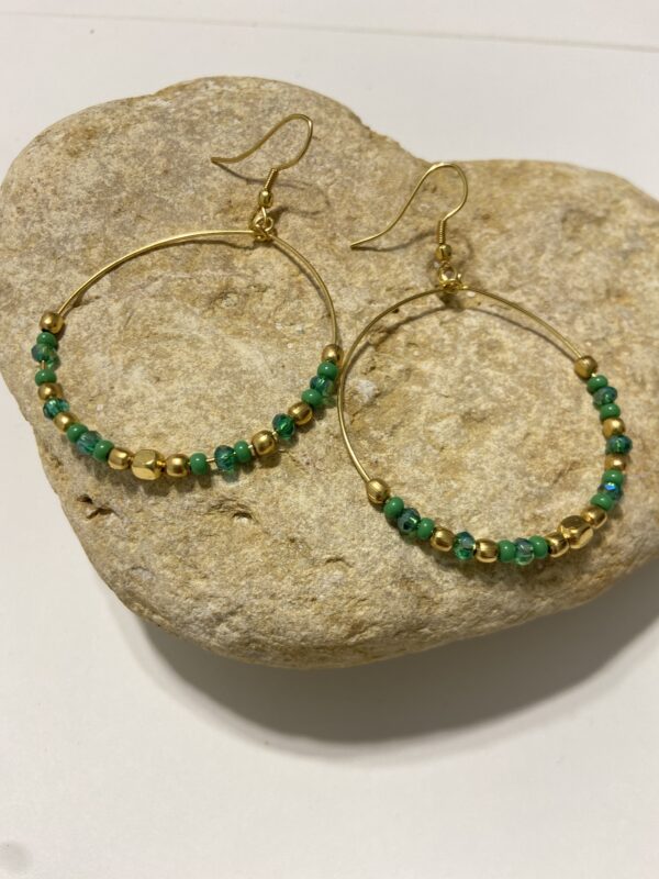 Orecchini a cerchio in oro con perline dai colori vivaci. Design leggero e boho-chic, perfetto per ogni occasione. Disponibile in 5 tonalità.