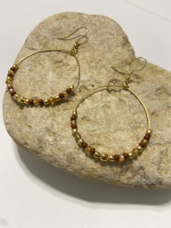 Orecchini a cerchio in oro con perline dai colori vivaci. Design leggero e boho-chic, perfetto per ogni occasione. Disponibile in 5 tonalità.