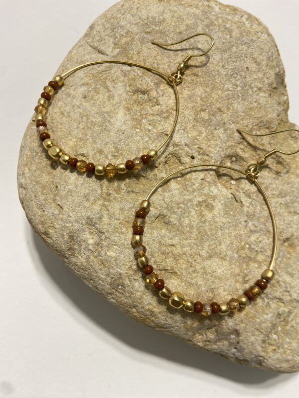 Orecchini a cerchio in oro con perline dai colori vivaci. Design leggero e boho-chic, perfetto per ogni occasione. Disponibile in 5 tonalità.