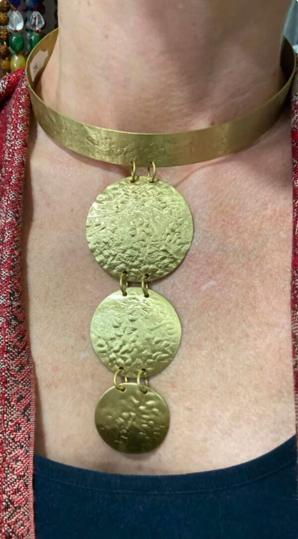 Collana rigida con tre anelli pendenti in ordine di grandezza. Un gioiello esclusivo per chi vuole distinguersi con stile. Questa collana è il simbolo di un'eleganza senza pari. Ideale per le occasioni speciali o per valorizzare qualsiasi outfit quotidiano. Materiale: metallo color oro Lunghezza: regolabile per il comfort Fatto a mano in India